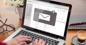 Woman checking work email on laptop at desk